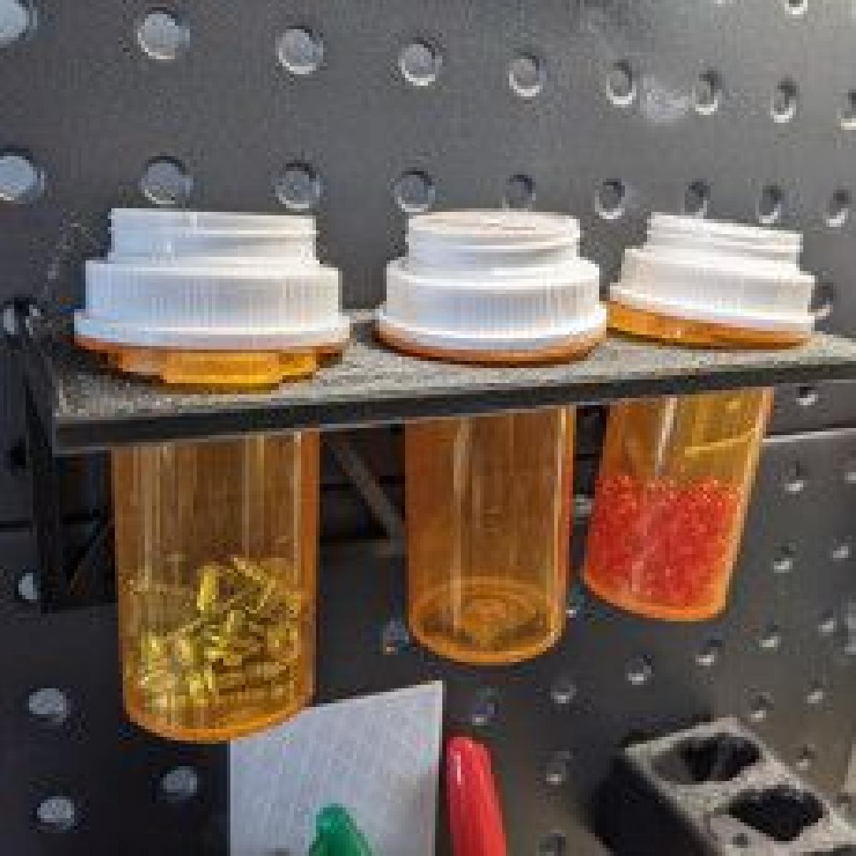 Suporte para recipiente de medicamentos em painel perfurado