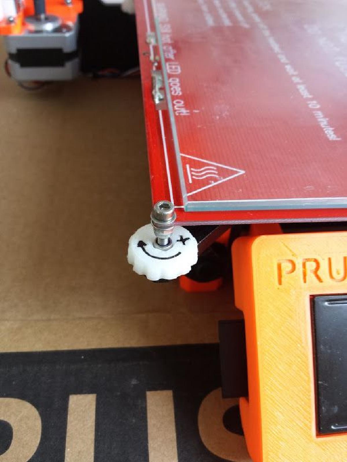 Ajustador de cama Prusa i3 com uma seta de direcao.