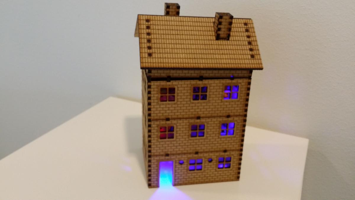 Casa de tijolos de multiplos andares cortada a laser com luzes LED.