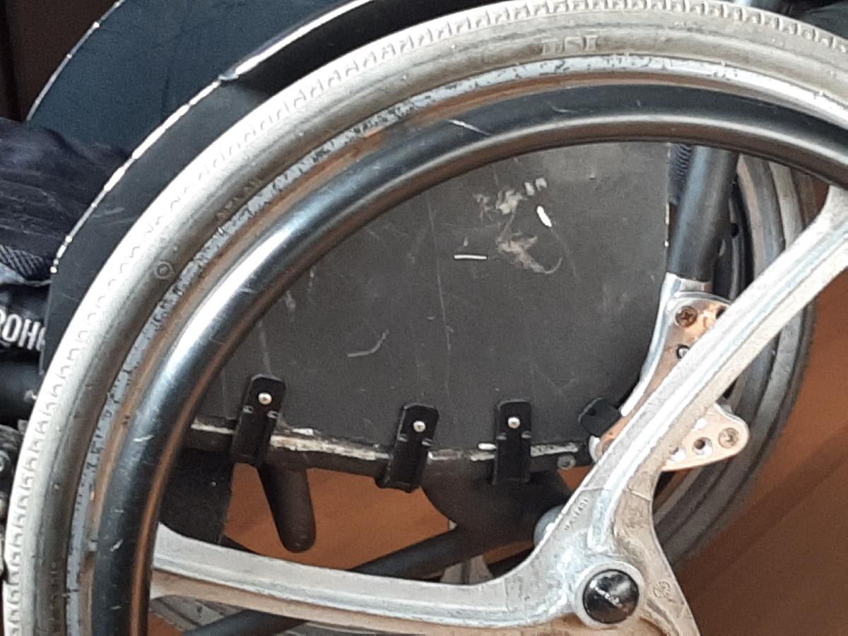 Gancho para fixar o protetor de roupas na cadeira de rodas Engate para fixar o protetor de roupas na cadeira de rodas