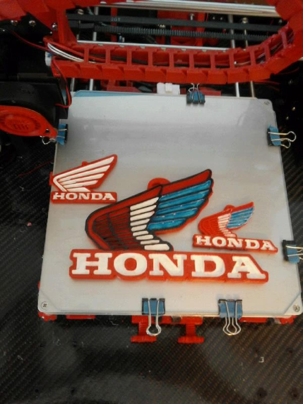 Chaveiro ou arte de parede da Honda nas cores vermelha, branca e azul.